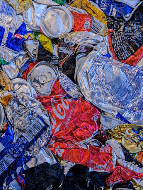 A large pile of mixed household rubbish and waste materials scattered across a paved surface, including crumpled paper, plastic bottles, and various discarded packaging. The waste appears unorganized, with some items partially crushed or flattened, and the surface beneath visible in some areas. Plastic bottles are predominantly transparent with labels still attached, some cap closures visible, and they are lying on their sides or upright amidst crumpled paper and other debris. Cardboard packaging and paper waste are crumpled and piled irregularly, with some torn or shredded. The environment suggests an outdoor setting, possibly a driveway or a waste collection point, with natural lighting casting minimal shadows. The scene conveys a typical example of improperly disposed rubbish that might be handled through private waste clearance services like Rubbish Clearance Uxbridge, often necessary when waste exceeds regular council collection limits or involves bulk or miscellaneous items requiring on-site clearance. This detailed visual description emphasizes the variety and disorder of general household waste materials suitable for professional rubbish removal or disposal solutions.